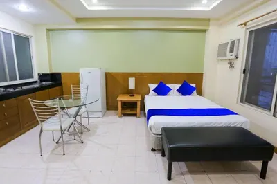 a bedroom with a bed and a table and a window at Alley 8 Makati in Manila