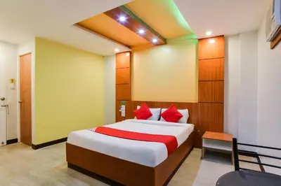 a bedroom with a large bed with red pillows at OYO 473 Ranchotel Drive-in in Biñan