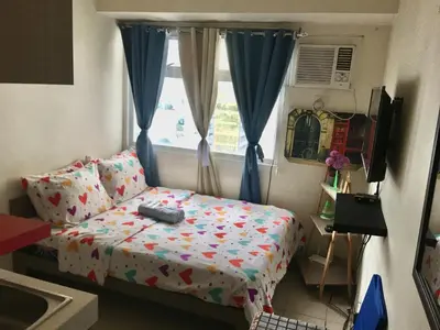 a small bedroom with a bed and a window at Booker Com in Mandaluyong in Manila