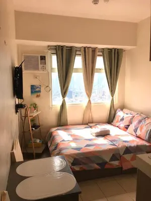 a small bedroom with a bed and a window at Booker Com in Mandaluyong in Manila
