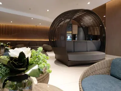a lobby with a chair and a table with flowers at Tower C Shore Residences by CSLUXE in Manila