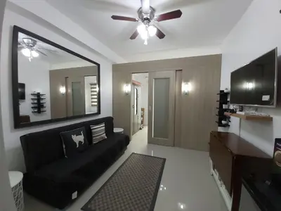 a living room with a black couch and a ceiling fan at Tower C Shore Residences by CSLUXE in Manila