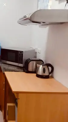 a tea kettle on a counter next to a microwave at Makati CBD Resort 2 bedroom in Manila