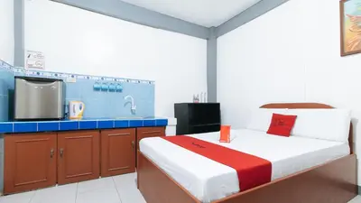a bedroom with a bed and a kitchen with a tv at RedDoorz at A&F C5 Pinagsama Taguig in Manila