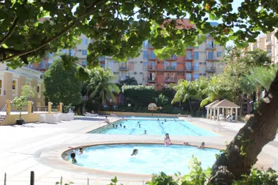 a large swimming pool with people in it at Chateau Elysee a14 near Airport Wifi Kitchen in Manila
