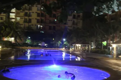 a large pool of blue water at night at Chateau Elysee a14 near Airport Wifi Kitchen in Manila