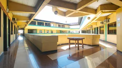 a hallway of a school building with a table in the middle at RedDoorz near SM City Muntinlupa in Manila