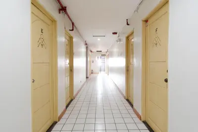 a corridor of a hospital hallway with yellow doors at RedDoorz Plus near Johnson and Johnson Paranaque in Manila