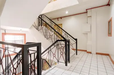 a staircase in a house with black railings at RedDoorz Plus near Johnson and Johnson Paranaque in Manila