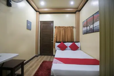 a hotel room with a bed with red pillows at Rjat Guesthouse in Biñan