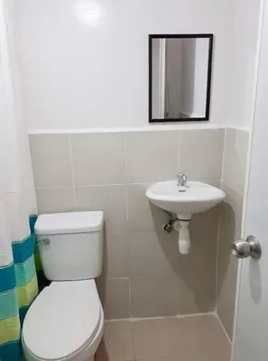 a bathroom with a toilet and a sink at Estien’s cozy condo to stay with kitchen in Manila