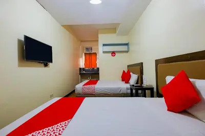 a hotel room with two beds and a flat screen tv at OYO 431 Apollo 11 Apartelle in Manila