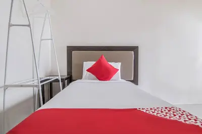 a bedroom with a bed with a red pillow at OYO 431 Apollo 11 Apartelle in Manila