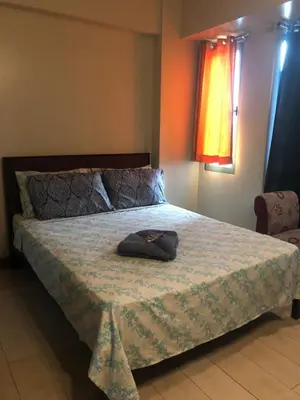 a bedroom with a bed with a hat on it at Favila Condotel unit in Palmtree Villas Newport City walking distance to Airport terminal 3 Accessable to Airport terminal 1 &2 in Manila