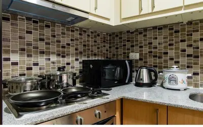 a kitchen counter with pots and pans on a stove at Madisons Crib at The Florence in Manila