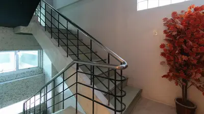 a staircase with a metal railing and a plant at RedDoorz near Quiapo Church Manila in Manila