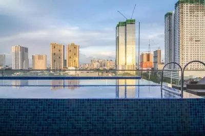 a swimming pool with a city skyline in the background at ARK Hostel City Center Manila in Manila