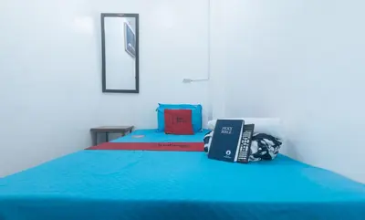 a bedroom with a blue bed with a book on it at RedDoorz near OWWA Pasay in Manila