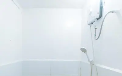 a shower in a bathroom with a white wall at RedDoorz near OWWA Pasay in Manila