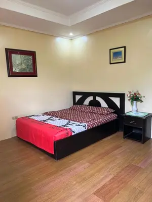a bedroom with a bed with a red comforter and a table at INN D’ZaireH in Molino