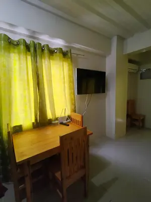 a room with a wooden table and yellow curtains at Mhavic family room ,group friend good for 6 guest in Manila
