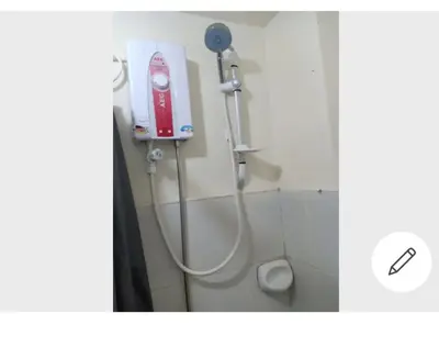a bathroom with a shower with a hair dryer at Mhavic family room ,group friend good for 6 guest in Manila