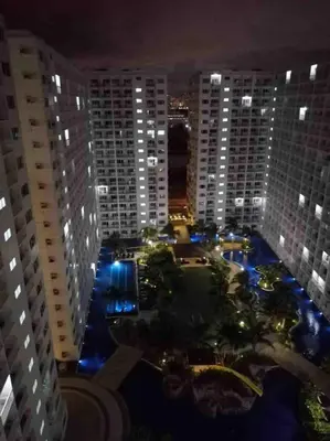 a view of a city at night with tall buildings at Sithonia Suite, Shore Residences Tower C near MOA in Manila