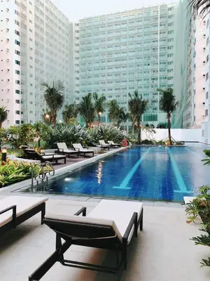 a large swimming pool in a large building with benches at Sithonia Suite, Shore Residences Tower C near MOA in Manila