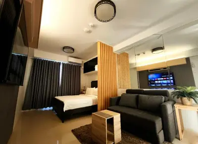 a living room with a couch and a bed at Sithonia Suite, Shore Residences Tower C near MOA in Manila
