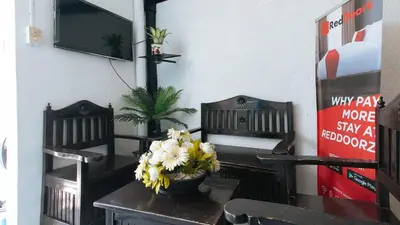 a dining room with a table with flowers on it at RedDoorz Plus at Villa Gloria Taguig in Manila
