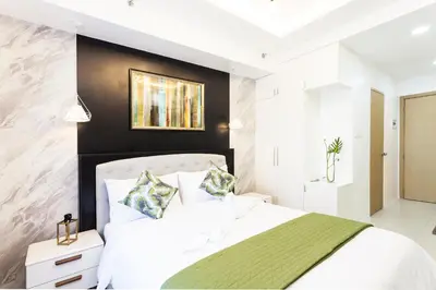 a bedroom with a white bed and a black wall at Elegant Living at Grace Residences T3-2206 Taguig-Steps from SM Aura and BGC in Manila
