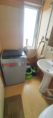 a small bathroom with a window and a sink at BGC Fort Victoria in Manila
