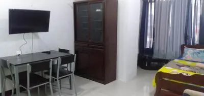 a room with a desk and a bed and a television at Your City•Home Apartment in Manila