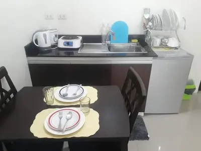 a kitchen with a table with plates and a sink at Your City•Home Apartment in Manila