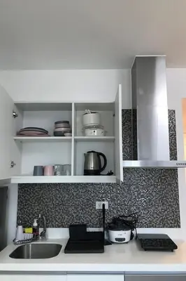 a kitchen with white cabinets and a sink at 1217 Urban Simplicity in Manila