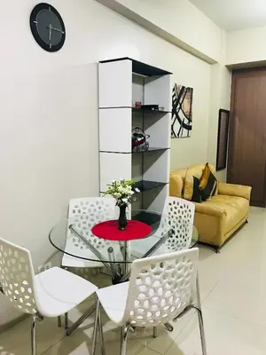 a living room with a glass table and chairs at Apartments across NAIA Terminal 3 in Manila