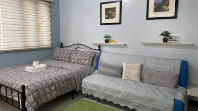 a bed and a couch in a room at Morgan Suite BGC shortwalk4 Venice Canal Mall free pool gym in Manila