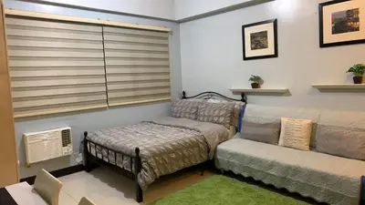 a living room with a bed and a couch at Morgan Suite BGC shortwalk4 Venice Canal Mall free pool gym in Manila