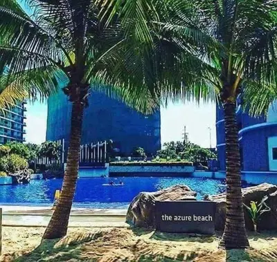 two palm trees in front of a swimming pool at Azure Urban Resort Residence a4 near airport mall with wavepool in Manila