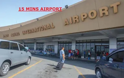 a man with a suitcase in front of a building at CHATEAU ELYSEE A10 near airport in Manila