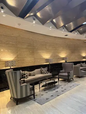 a lobby with a couch and chairs and a piano at City View at The Gramercy Residences in Makati
