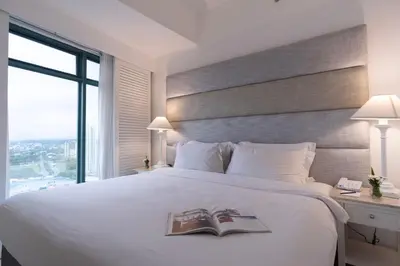 a bedroom with a large white bed with a book on it at Vivere Hotel and Resorts in Manila