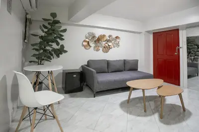 a living room with a couch and a table and chairs at Circuit Hostel in Manila