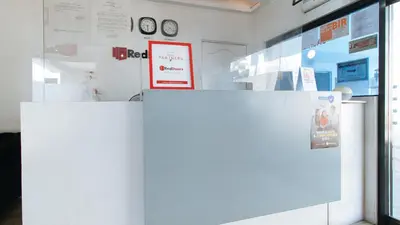a white refrigerator in a room with clocks on the wall at RedDoorz near SM Calamba in Laguna
