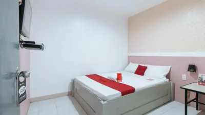 a small bedroom with a bed with white and pink walls at RedDoorz near SM Calamba in Laguna