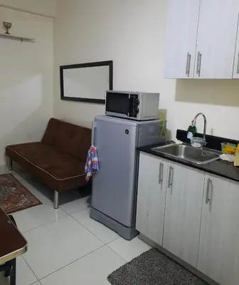 a kitchen with a microwave on top of a refrigerator at Green Residence 23rd Floor in Manila