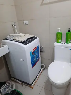 a bathroom with a washing machine and a toilet at Green Residence 23rd Floor in Manila