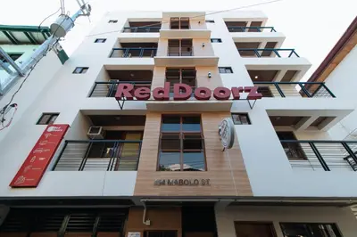 a building with a red door sign on it at RedDoorz Plus near Uptown BGC Mall in Manila