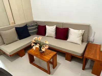 a living room with a couch with pillows and a table at 1BR Jazz Bel-air Makati, POOLVIEW, TRIDENT in Manila