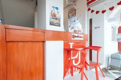 a kitchen with a wooden counter and a red chair at RedDoorz near Mercado del Lago in Manila